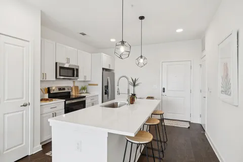 a kitchen with stainless steel appliances a dining table chairs stove microwave and cabinets