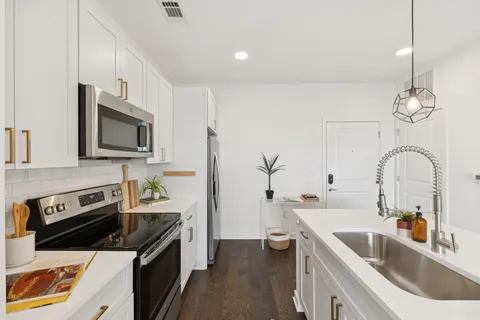 a kitchen with a sink cabinets and stainless steel appliances