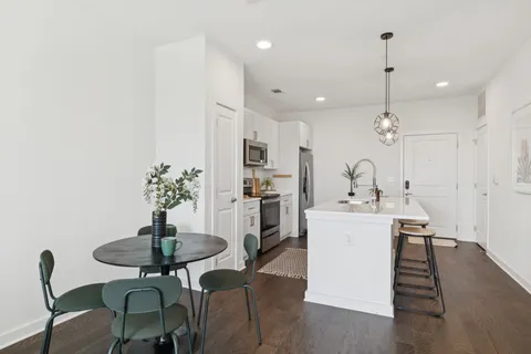 a kitchen with a dining table chairs sink and stove