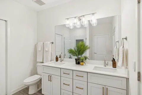 a bathroom with a granite countertop sink a toilet and a mirror