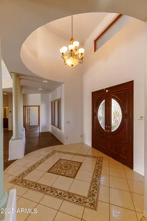 an empty room with chandelier fan and windows