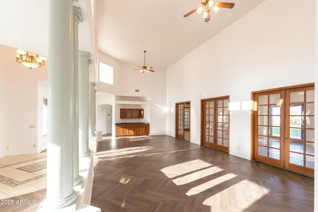 an empty room with fan and windows