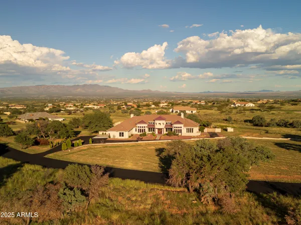 a living room with stainless steel appliances furniture a rug and a kitchen view