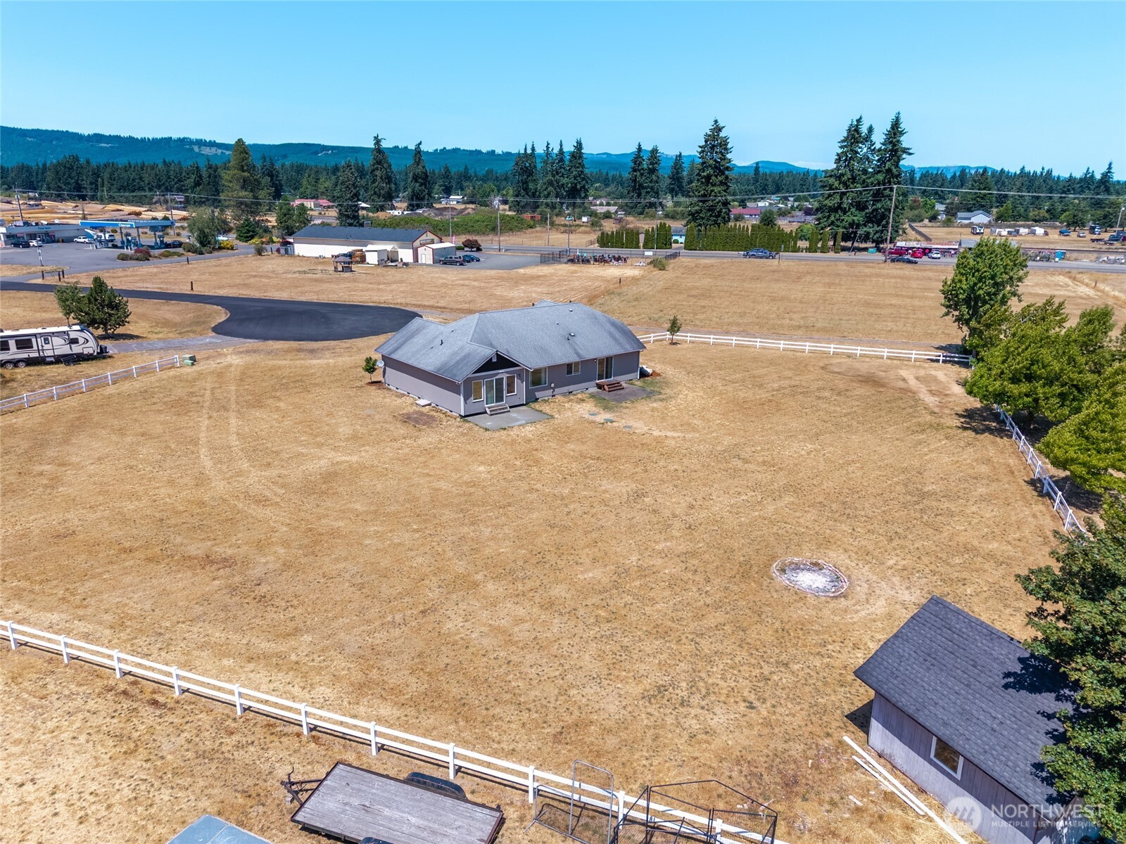 9519 184th Avenue Southwest Rochester, WA 98579 - Photo 38 of 38 a swimming pool view with a large trees and buildings in the background