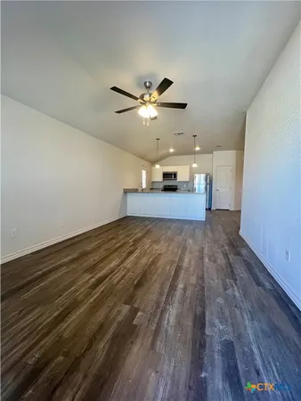 a view of a room with wooden floor and ceiling fan