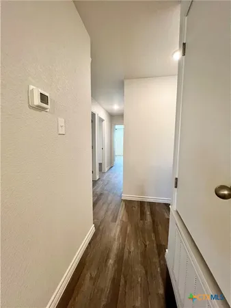 a view of a hallway with wooden floor