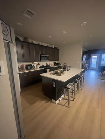 a kitchen with stainless steel appliances granite countertop a stove a sink dishwasher a refrigerator and a oven with wooden cabinets