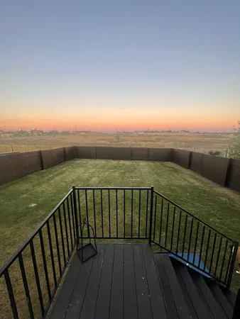 a view of balcony with wooden floor & fence