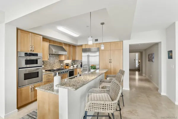 a kitchen with stainless steel appliances granite countertop a stove top oven a sink refrigerator and cabinets