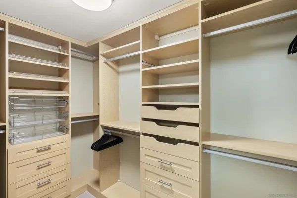 a view of walk in closet with empty racks