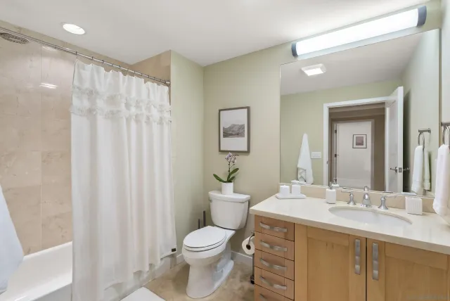 a bathroom with a double vanity sink toilet and a mirror