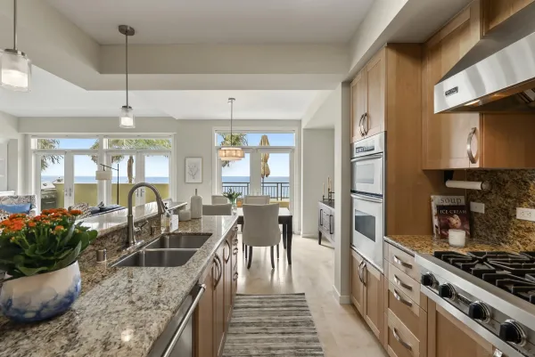 a kitchen with stainless steel appliances granite countertop a sink a stove and a wooden floors