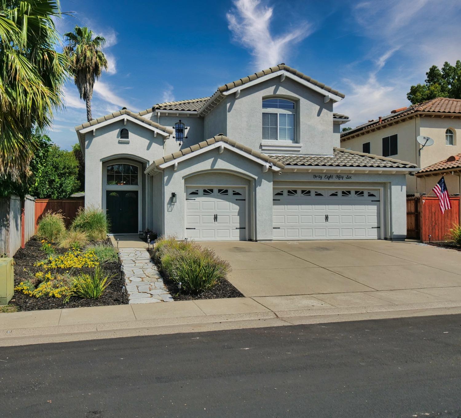 a front view of a house with a garden and garage