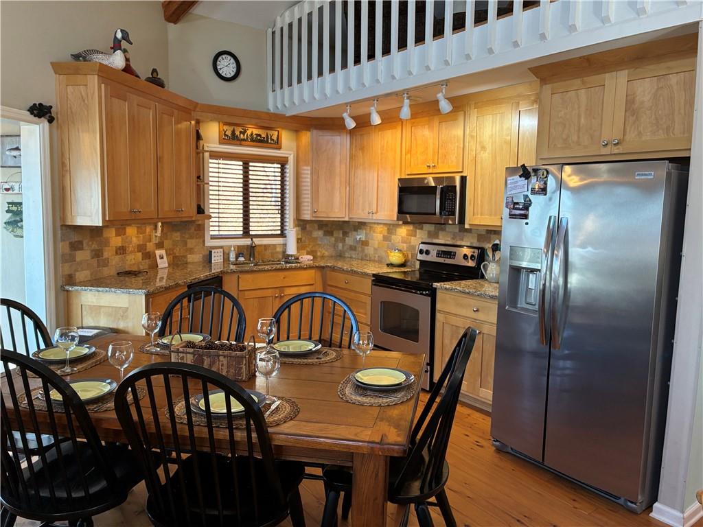 28 Little Hendricks Mountain Road Jasper, GA 30143 - Photo 4 of 42 a kitchen with stainless steel appliances granite countertop a stove a refrigerator a kitchen island a table and chairs