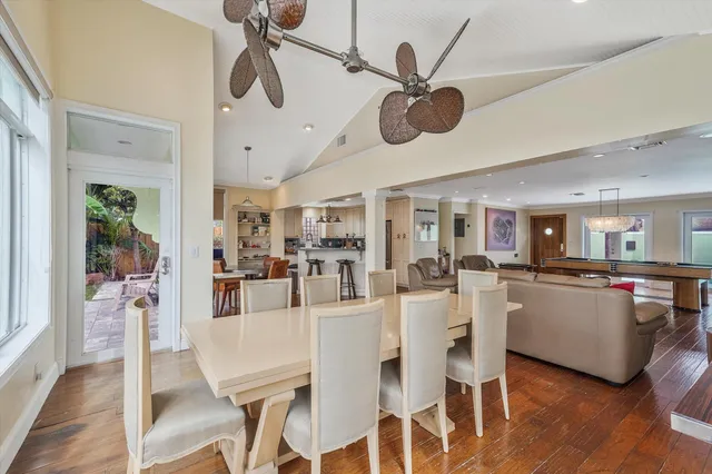 a view of a dining room and livingroom with furniture wooden floor a chandelier