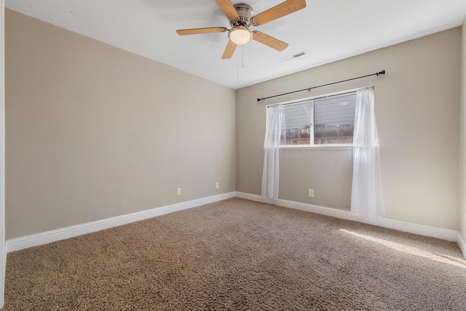 3317 Shamrock Avenue Merced, CA 95340 - Photo 16 of 44 an empty room with fan and windows