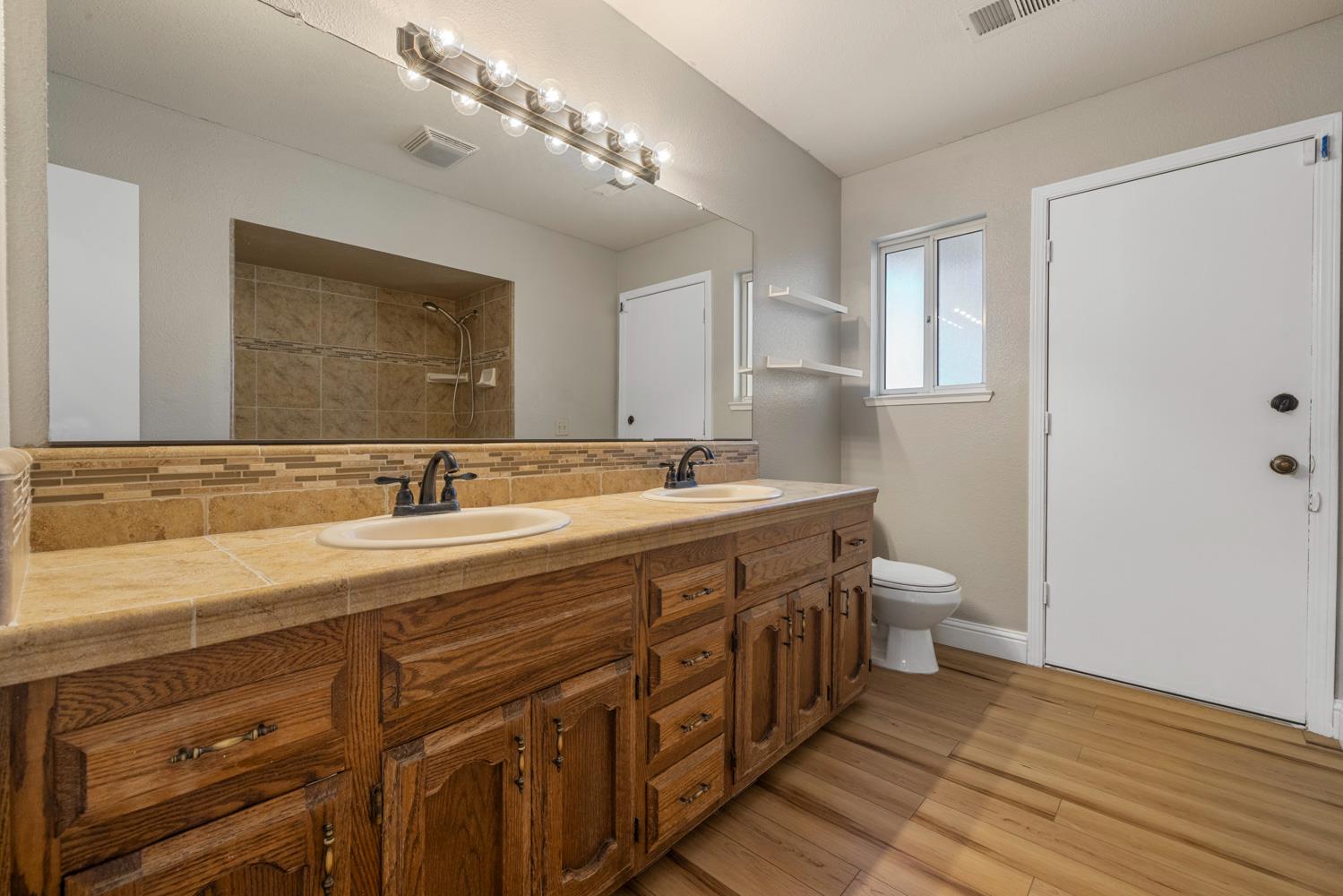3317 Shamrock Avenue Merced, CA 95340 - Photo 24 of 44 a bathroom with a double vanity sink and a mirror