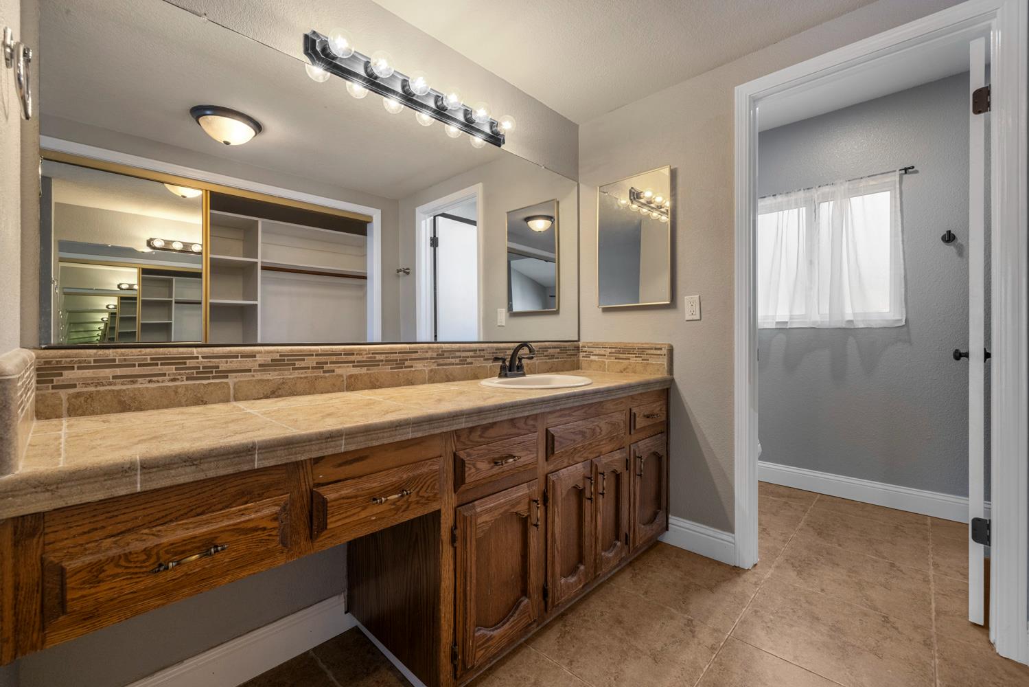 3317 Shamrock Avenue Merced, CA 95340 - Photo 28 of 44 a spacious bathroom with a double vanity sink and a mirror