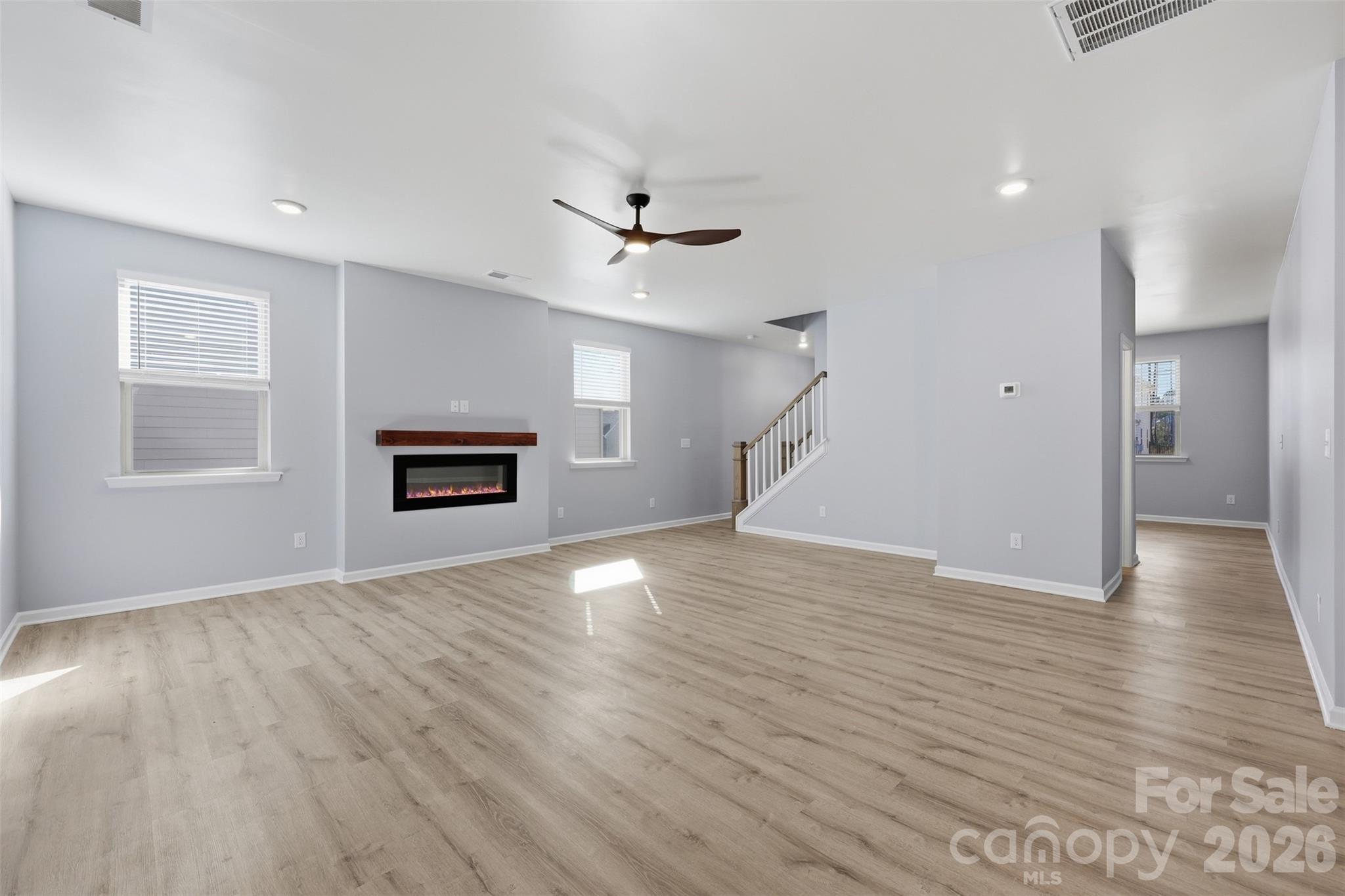 2220 Sussex Road York, SC 29745 - Photo 9 of 42 an empty room with wooden floor chandelier fan and windows
