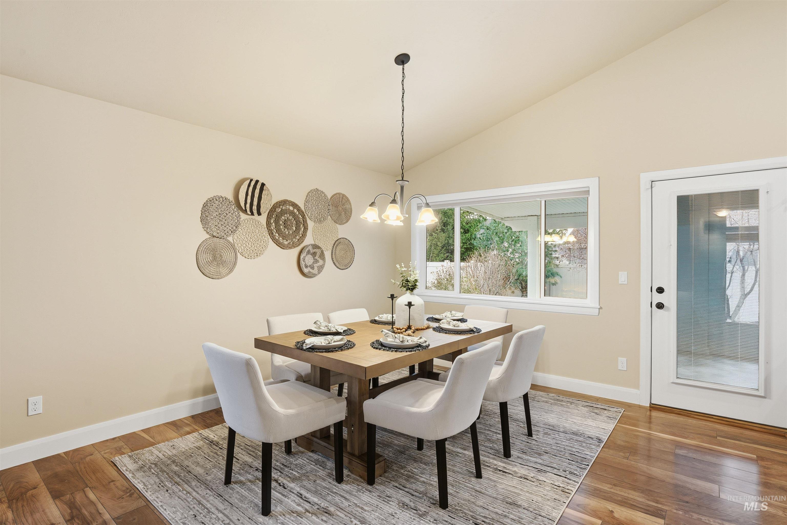 5697 Combermere Drive Eagle, ID 83616 - Photo 16 of 43 Dining room featuring lofted ceiling, light wood-style flooring, and a chandelier