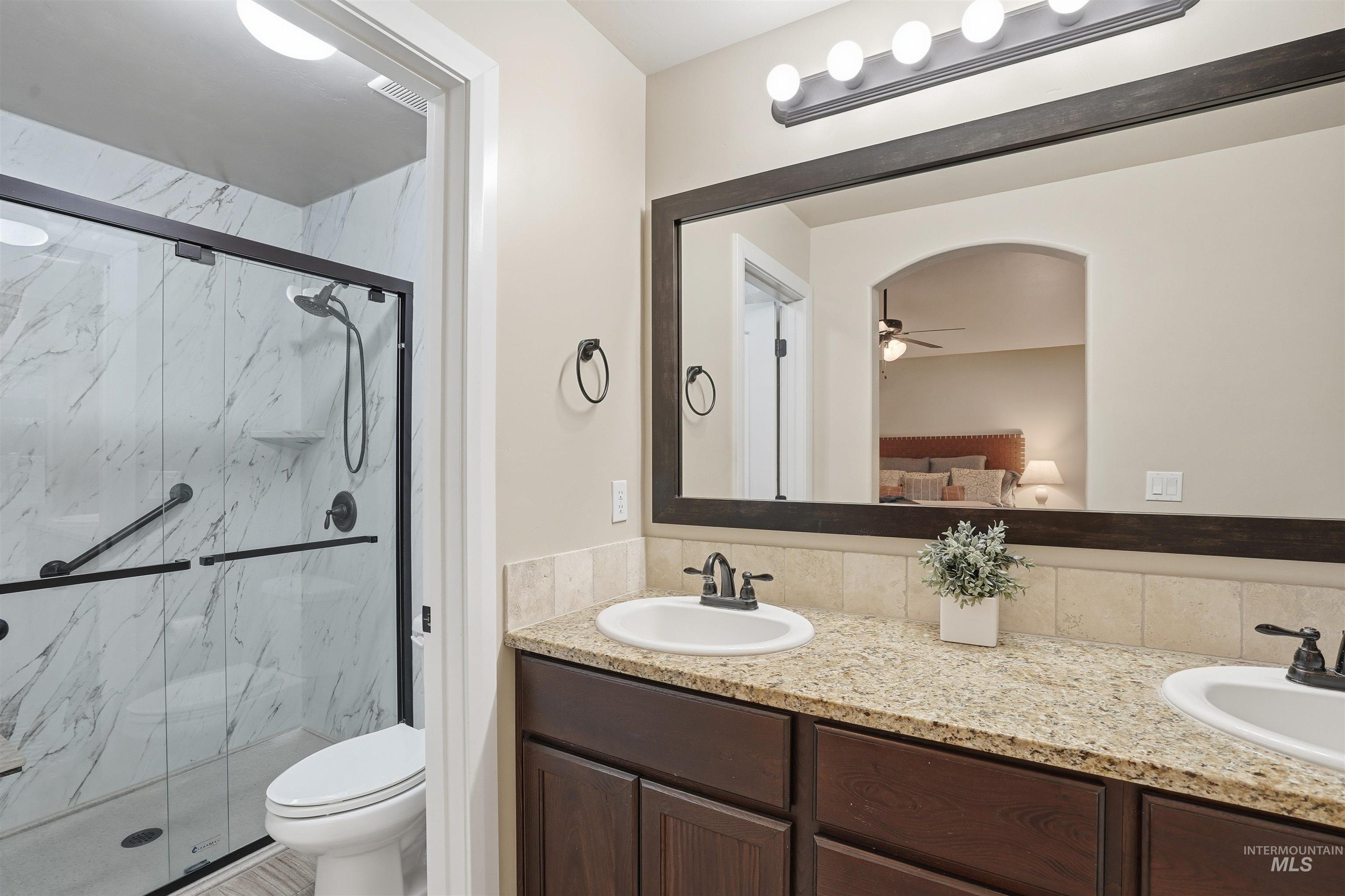 5697 Combermere Drive Eagle, ID 83616 - Photo 20 of 43 Bathroom with connected bathroom, double vanity, a marble finish shower, and ceiling fan