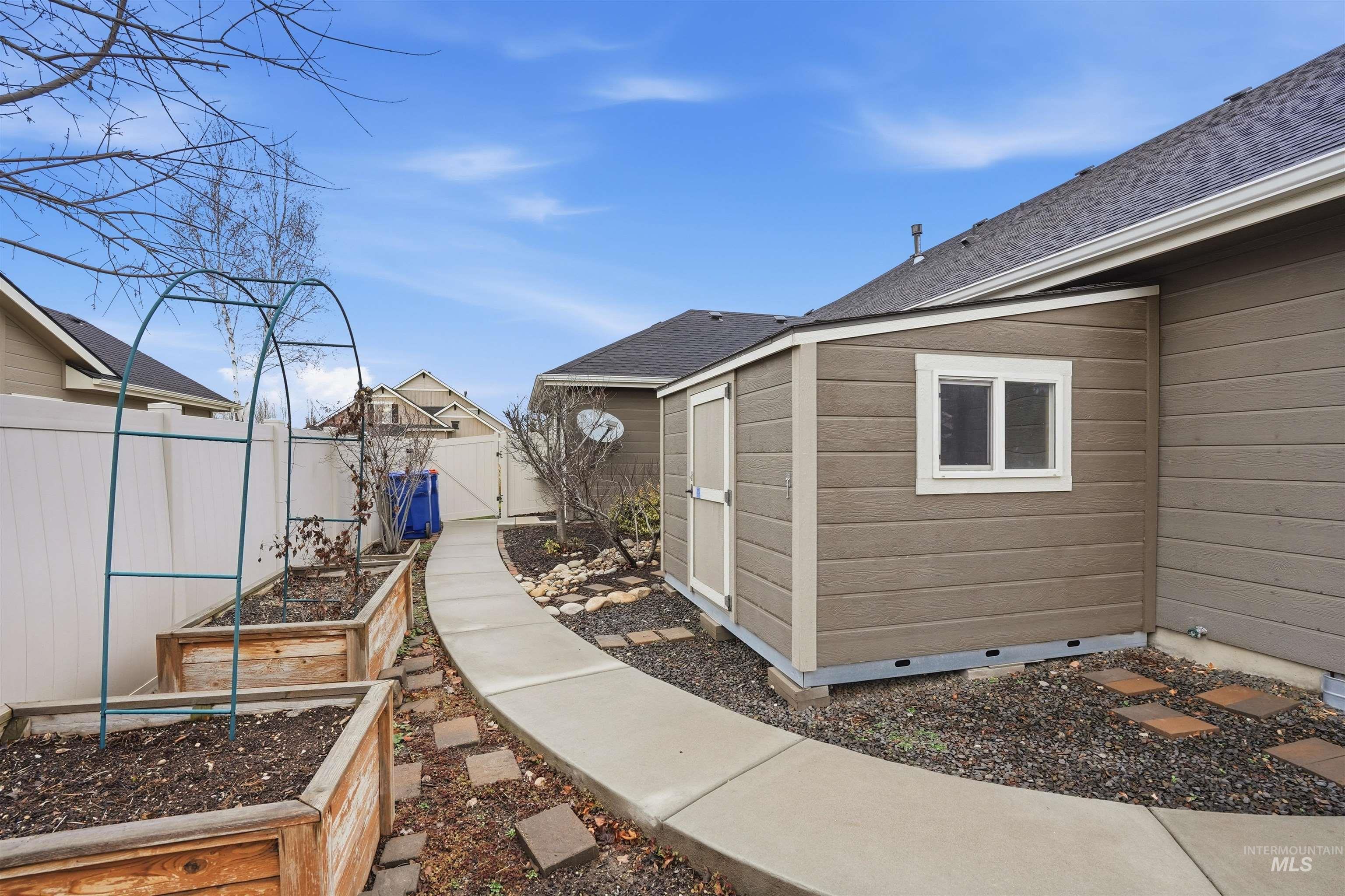 5697 Combermere Drive Eagle, ID 83616 - Photo 36 of 43 View of property exterior featuring crawl space, a vegetable garden, a shingled roof, and an outdoor structure