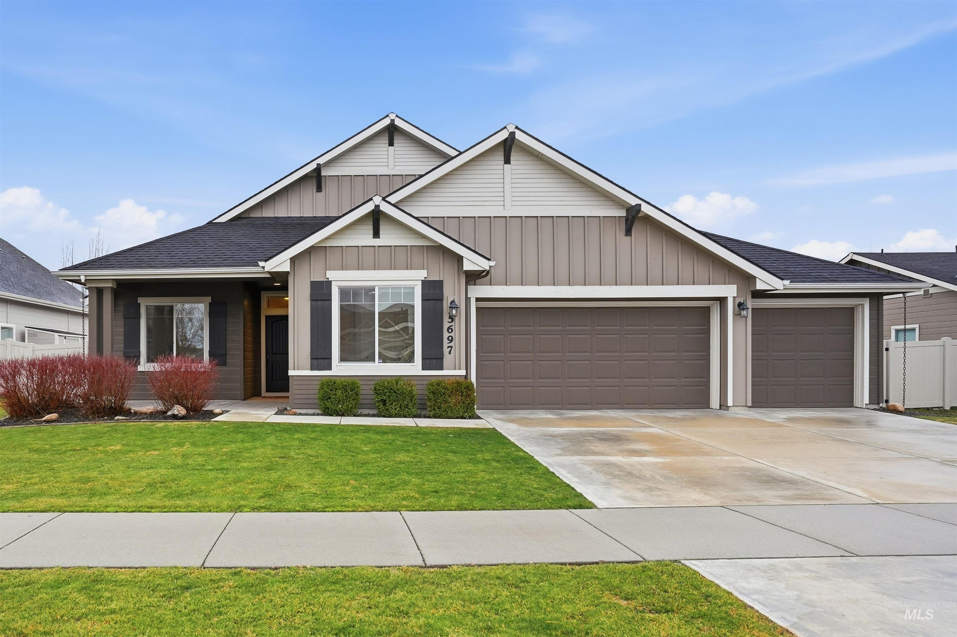 5697 Combermere Drive Eagle, ID 83616 - Photo 38 of 43 View of front facade featuring an attached garage, driveway, roof with shingles, and board and batten siding