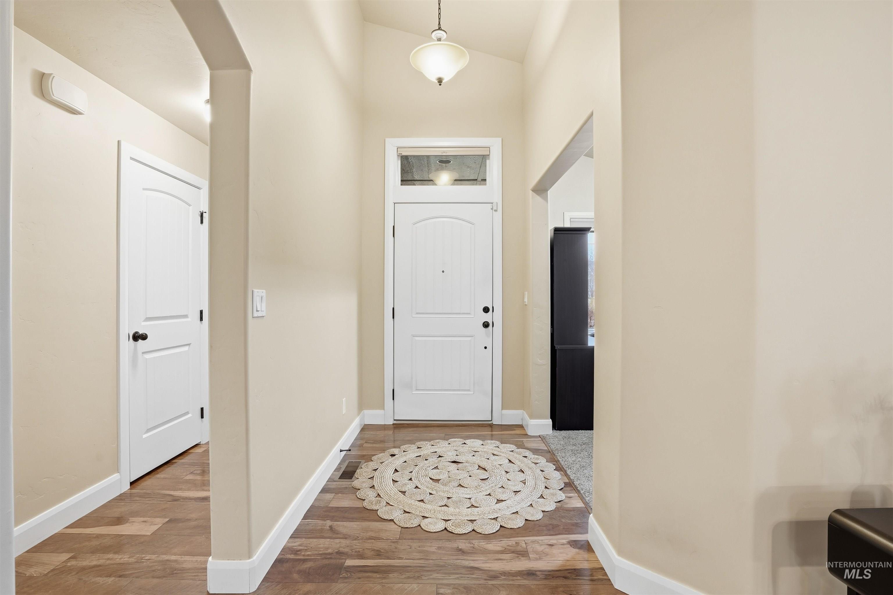 5697 Combermere Drive Eagle, ID 83616 - Photo 5 of 43 Entryway with lofted ceiling, light wood-style flooring, and arched walkways