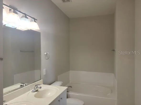 a white bath tub sitting next to a white sink and a toilet