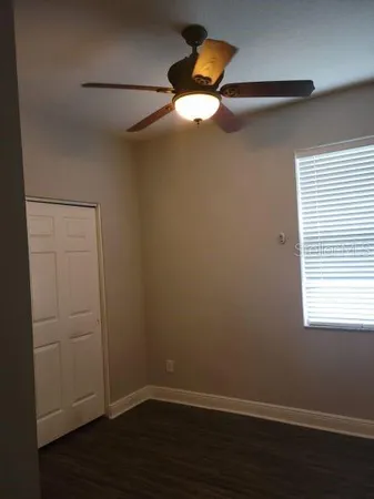 a view of a small space with wooden floor fan and windows