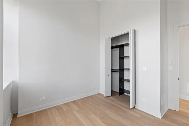 a view of an empty room with closet and a window