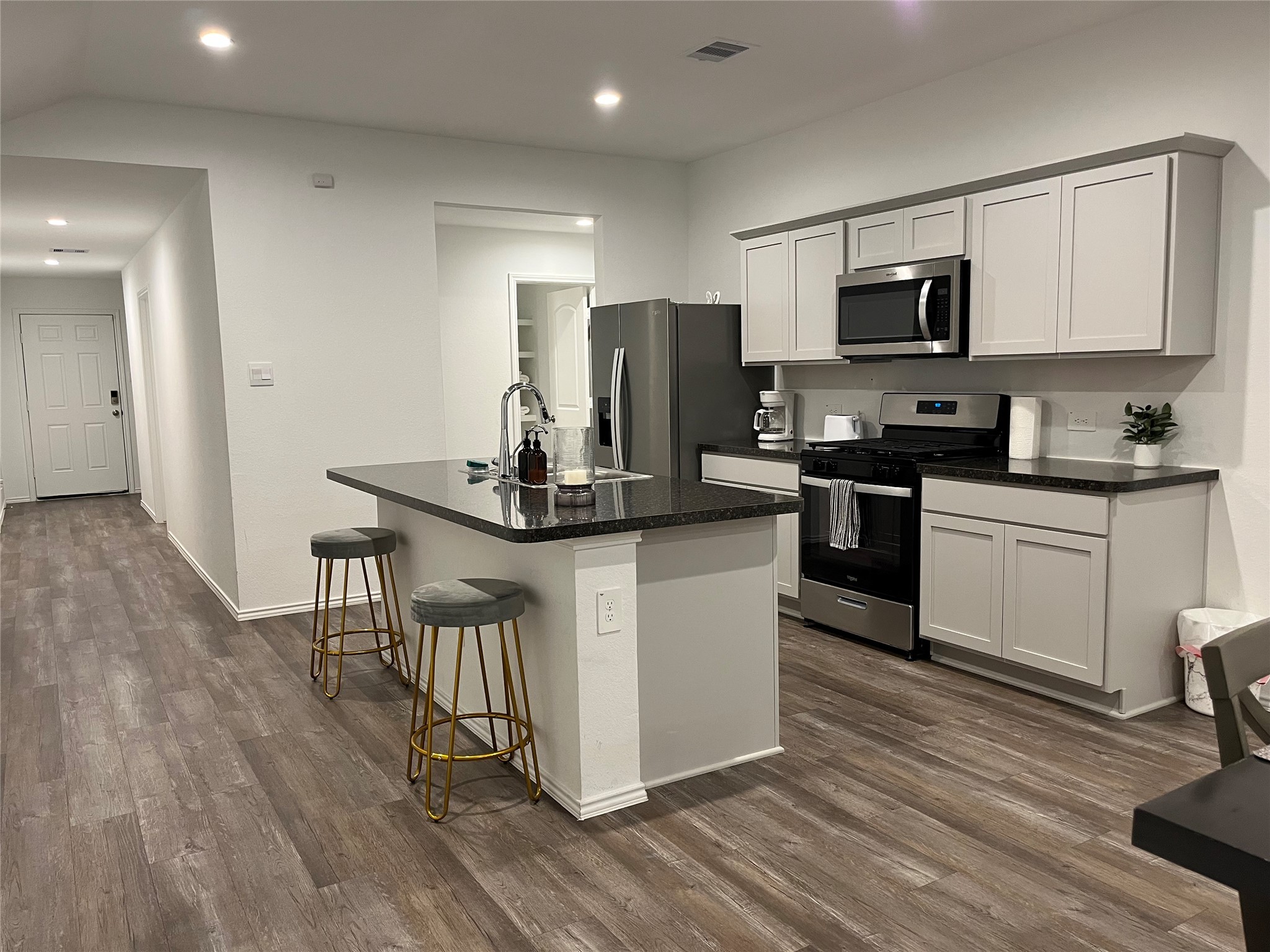 5446 Wyndham Ridge Ln Spring Spring, TX 77373 - Photo 1 of 24 a kitchen with stainless steel appliances granite countertop a stove top oven a sink dishwasher a refrigerator and white cabinets with wooden floor
