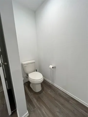 a white toilet sitting next to a white cabinet