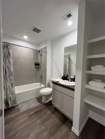 a bathroom with a granite countertop sink a toilet and shower