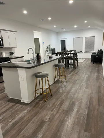 a kitchen with stainless steel appliances granite countertop a stove top oven a sink a counter space and cabinets