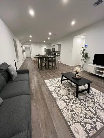 a living room with furniture a table and kitchen view