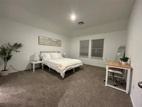 a spacious bedroom with a bed and a window