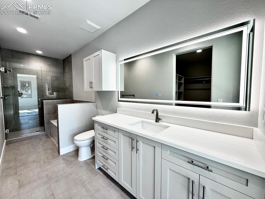 3155 Promise Point Colorado Springs, CO 80921 - Photo 19 of 26 a bathroom with a toilet sink and mirror