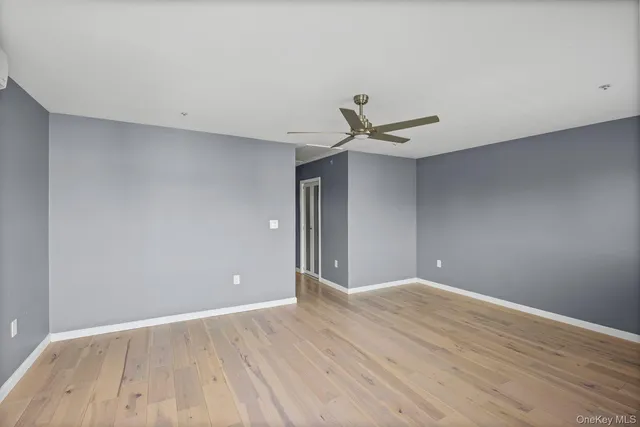 a view of a big room with wooden floor and a ceiling fan