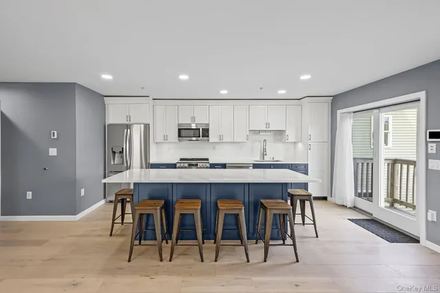 a large kitchen with kitchen island a dining table and chairs