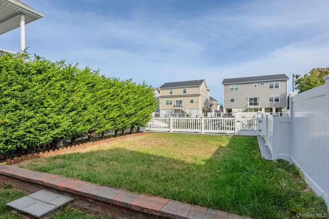 a view of a swimming pool with lawn chairs and a yard