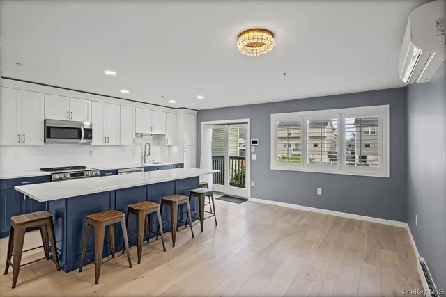 a large kitchen with stainless steel appliances granite countertop a stove a sink dishwasher and a refrigerator with wooden floor