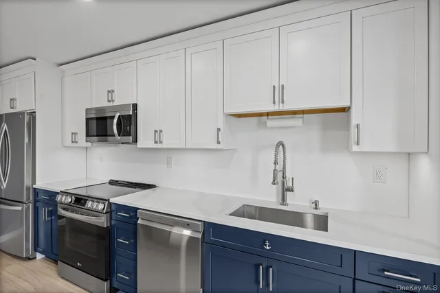 a kitchen with stainless steel appliances granite countertop white cabinets a sink and a stove