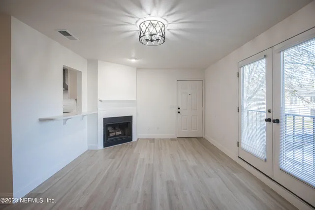 wooden floor fireplace and windows in an empty room