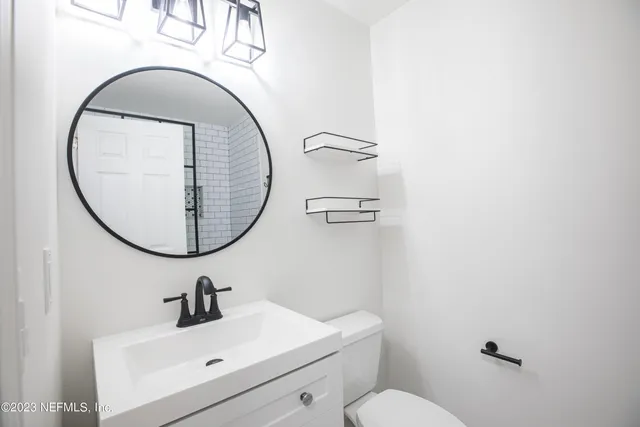 a bathroom with a sink mirror and toilet