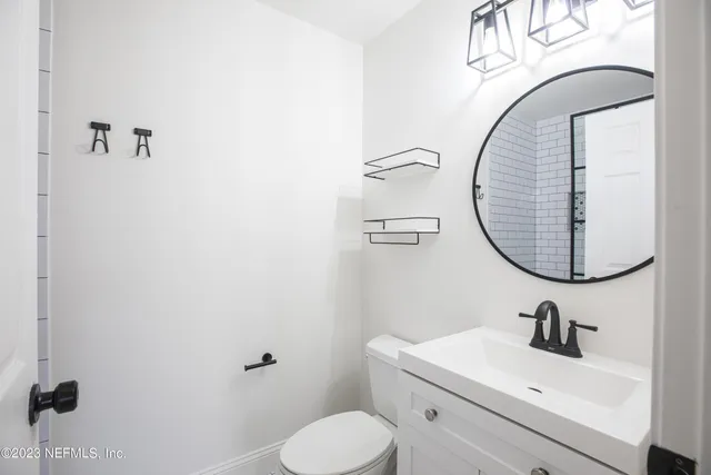 a bathroom with a toilet sink and mirror