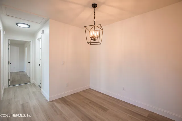 a view of a room with wooden floor and white walls