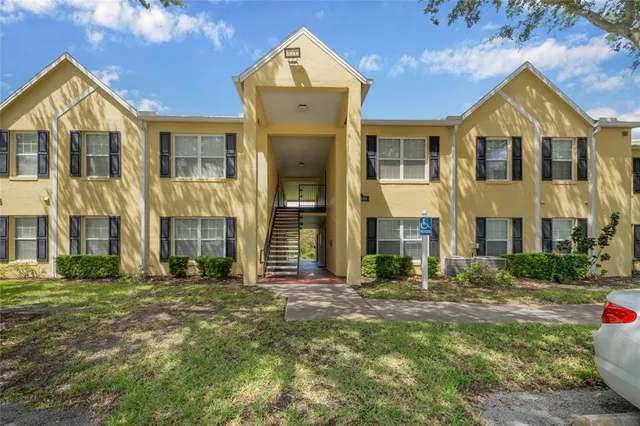 a view of a brick house with many windows and a yard