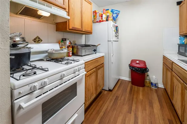 a kitchen with a stove and wooden floor