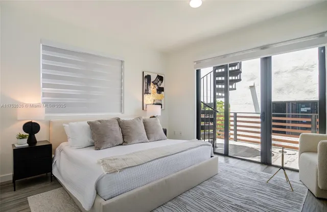 a bedroom with a bed and a large window